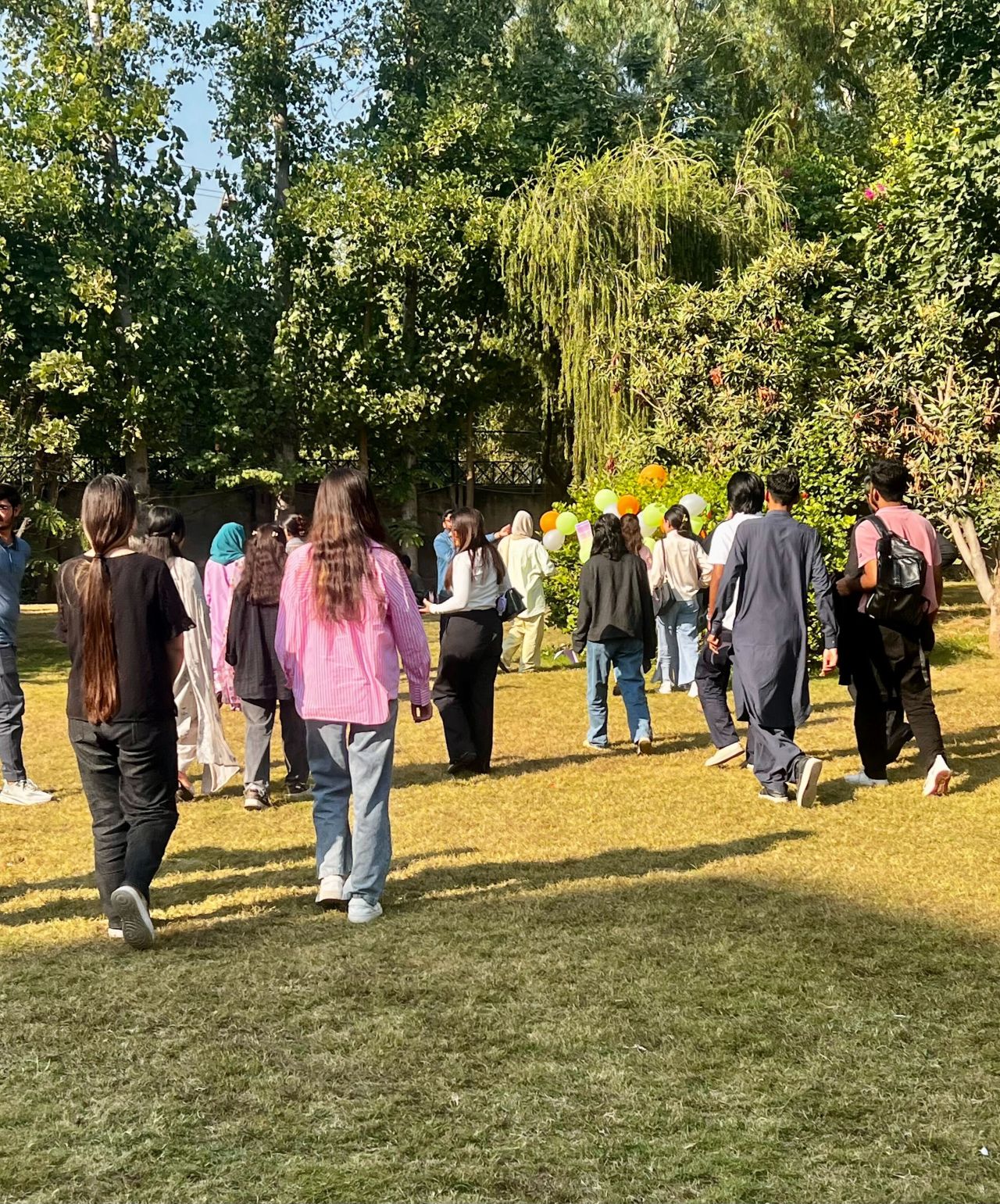 A group of people walking together through a sunny garden